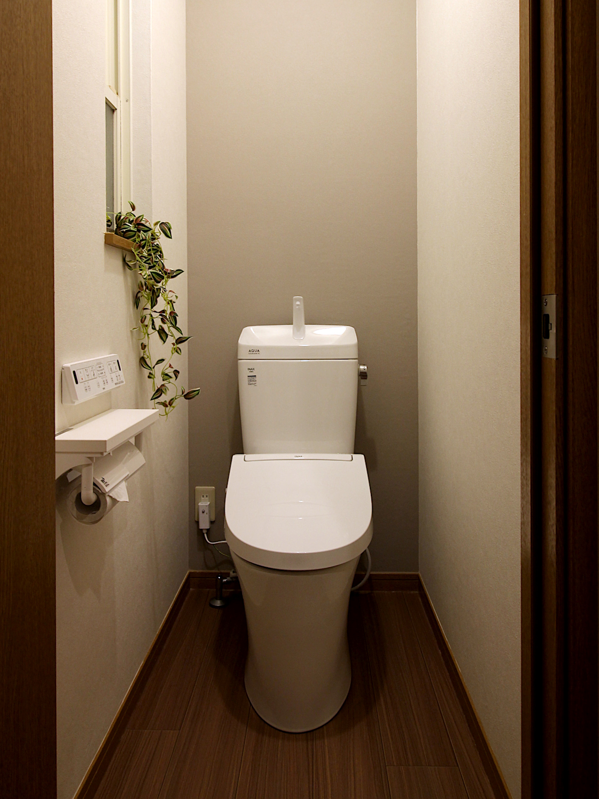 LIXILアメージュリトイレとシャワートイレKA31を採用したトイレリフォーム。ホワイトとグレージュのクロス(SP9731、SP9795)が明るく、木目フロアHM-11067がナチュラルな温かみを演出。