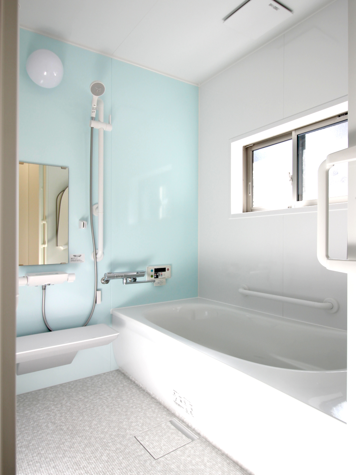 段差のない引戸や3方向の手すり、ほっカラリ床ホワイトラグ調など、安全と快適性を両立した名古屋市西区の浴室リノベーション。
