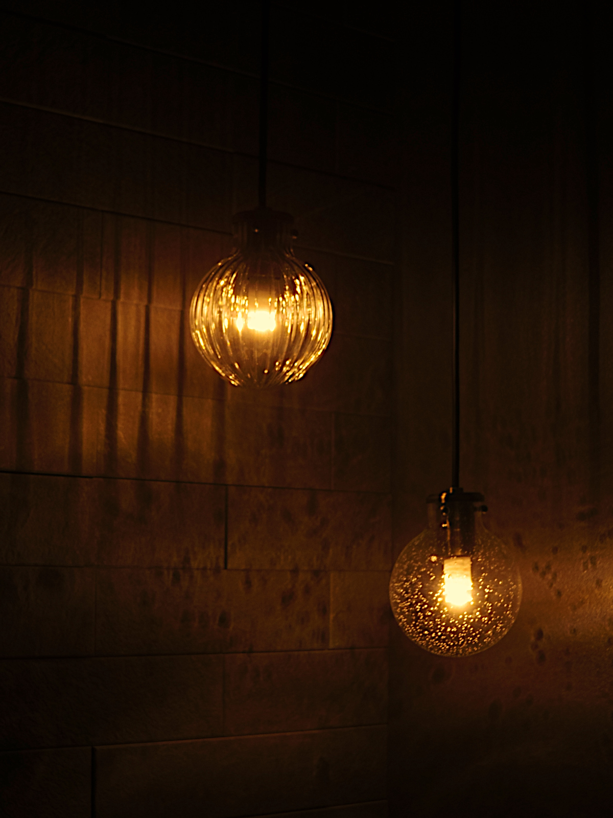 ODELIC製リブガラスのペンダントライト(OP252482LD2、OP252477LD2)。光がタイルに柔らかく反射し、ラグジュアリーなトイレリノベーションを実現。