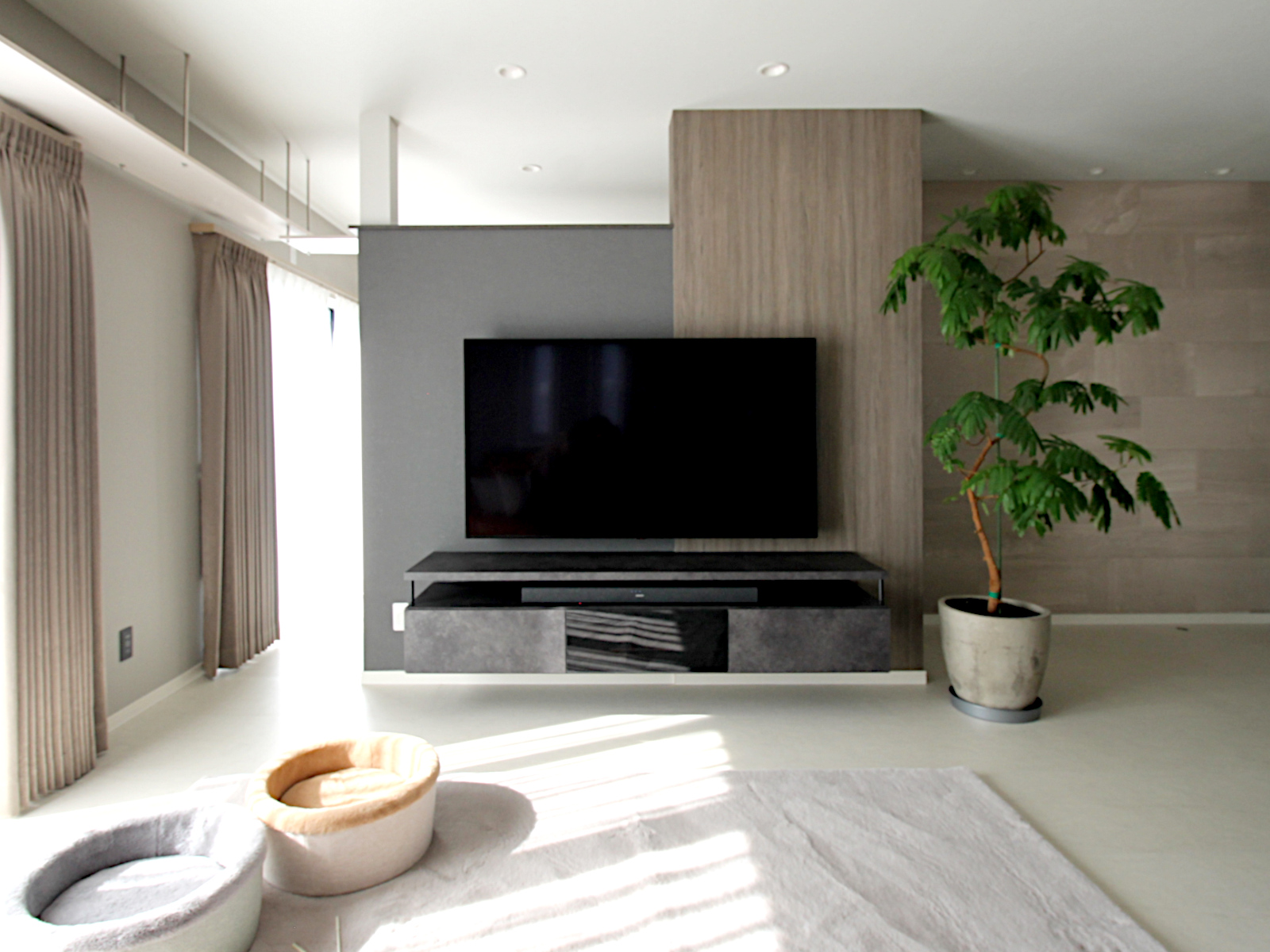 リビングリフォームの事例。ホワイトのフロアタイルとグレージュクロスで仕上げたモダン空間。TVボードはパモウナ製マージンキャビネットを採用。