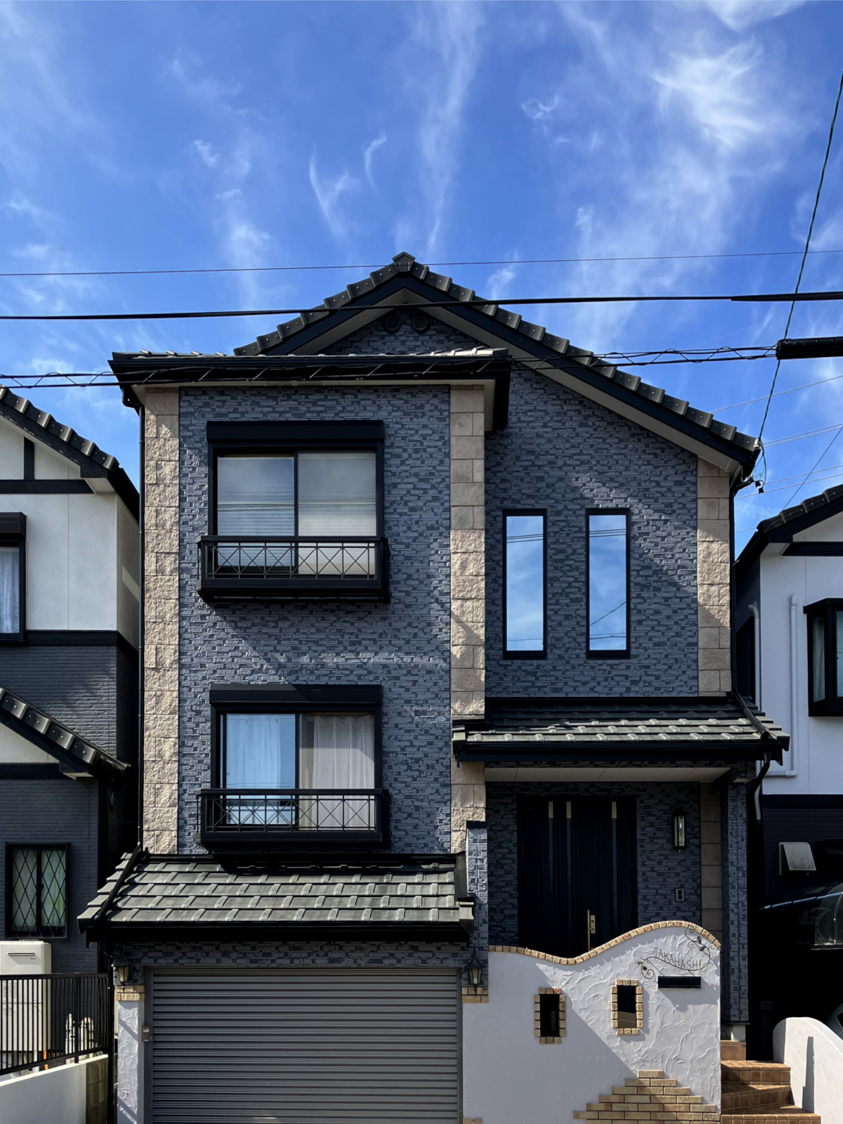 戸建て外壁リノベーション事例。二色の塗料を重ねるダブルトーン工法で、タイル柄の立体感を活かしたデザイン。