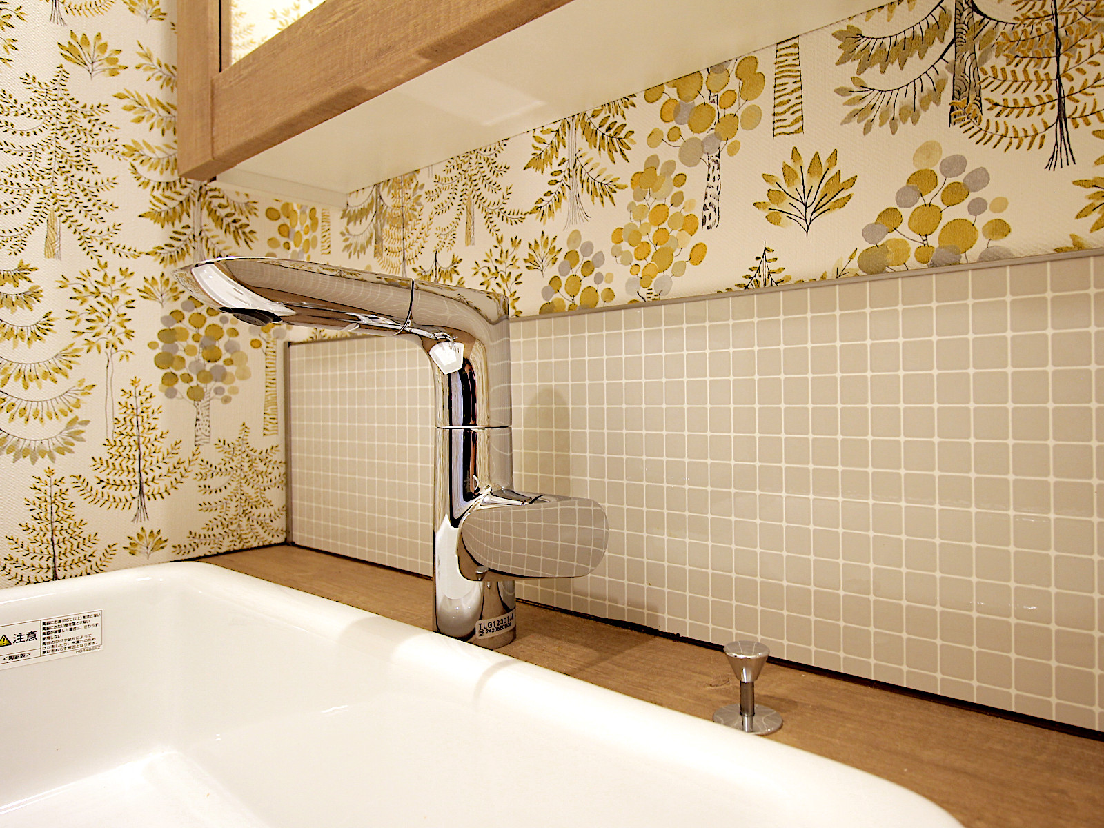 TOTOドレーナの水栓とタイル調パネル。