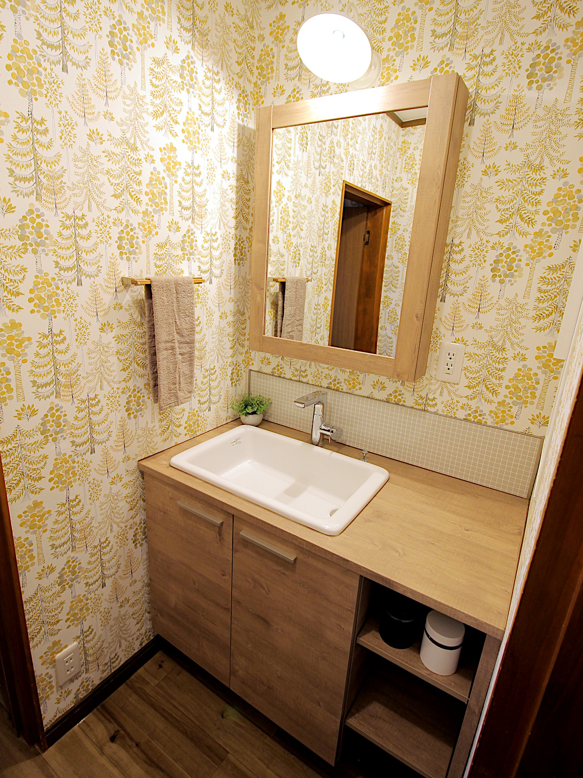 TOTOドレーナラフスモークウッドとサンゲツ77-3097の壁紙を使用した洗面リフォーム。