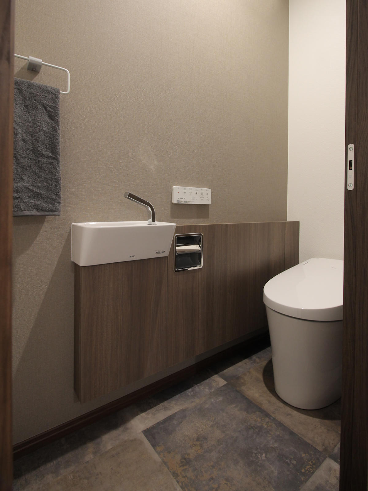 新設した2階トイレ。落ち着いたクロスとLIXILのサティスS手洗器付プランで統一感を演出した名古屋の戸建てリノベーション事例。