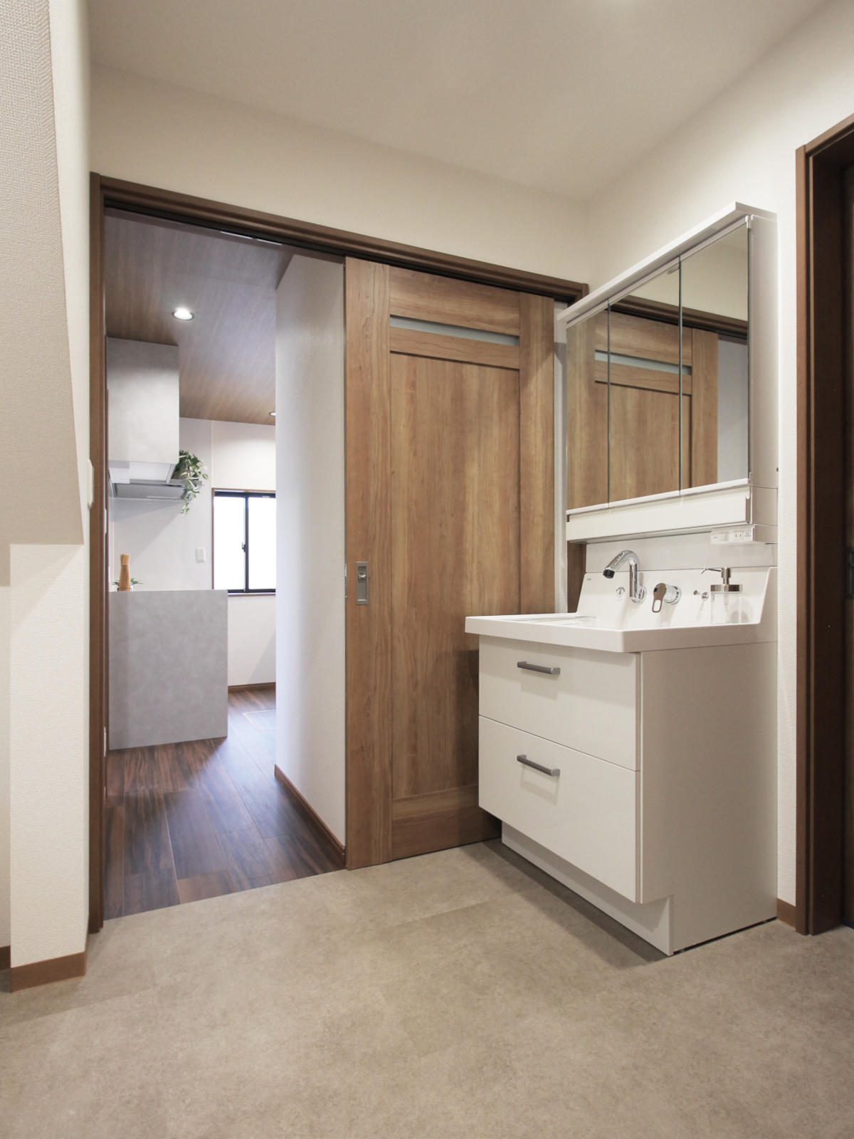 広く改修した洗面脱衣室。洗面化粧台はLIXILのピアラ、床材はサンゲツのフロアタイルIS-2025。名古屋の戸建てリノベーションで家事動線を快適に。