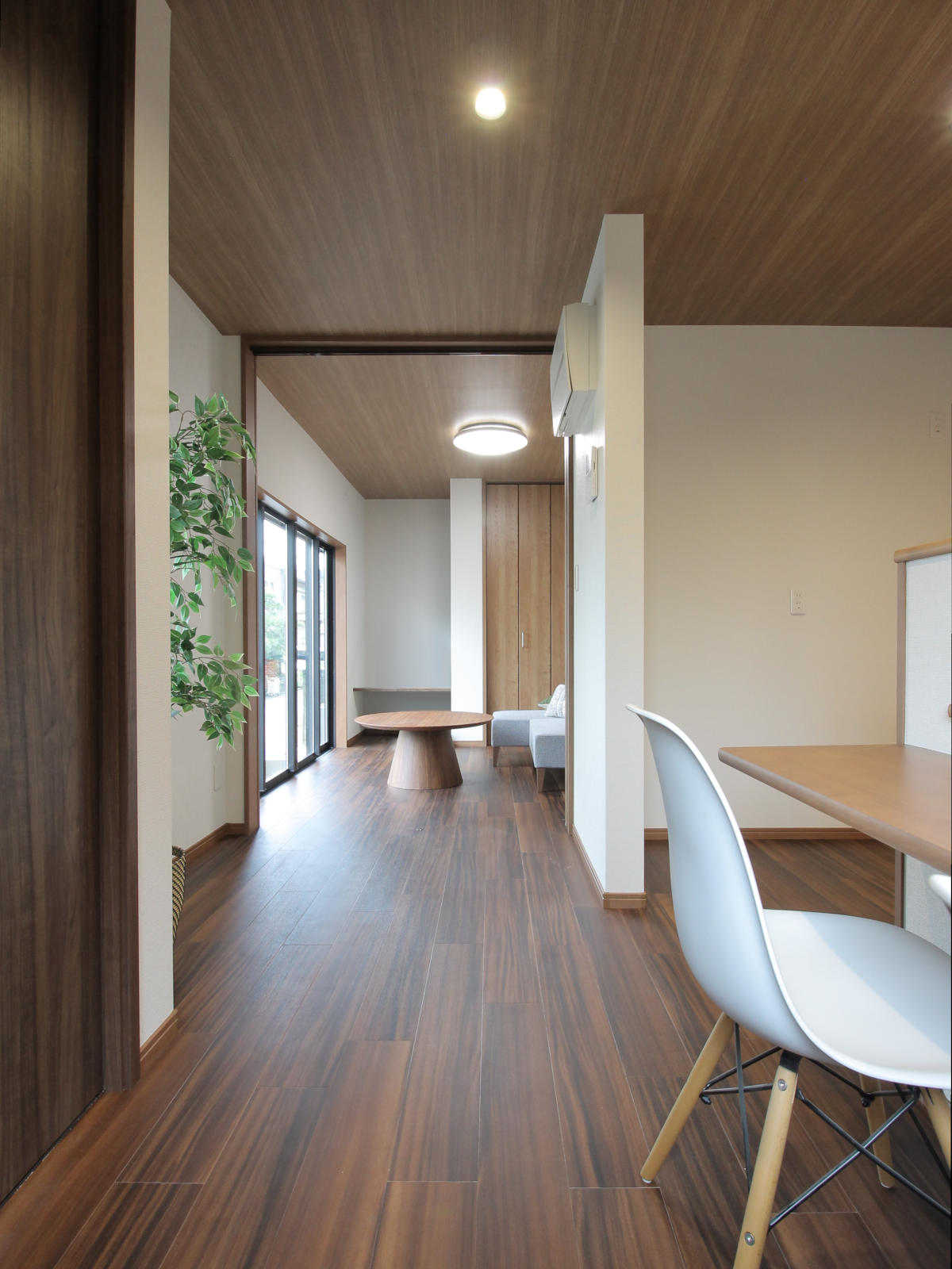 ダイニングからリビングへ続く見通しの良い空間。床はサンゲツのフロアタイルWD-2103。広がりを感じさせる戸建てリノベーションの住まい。