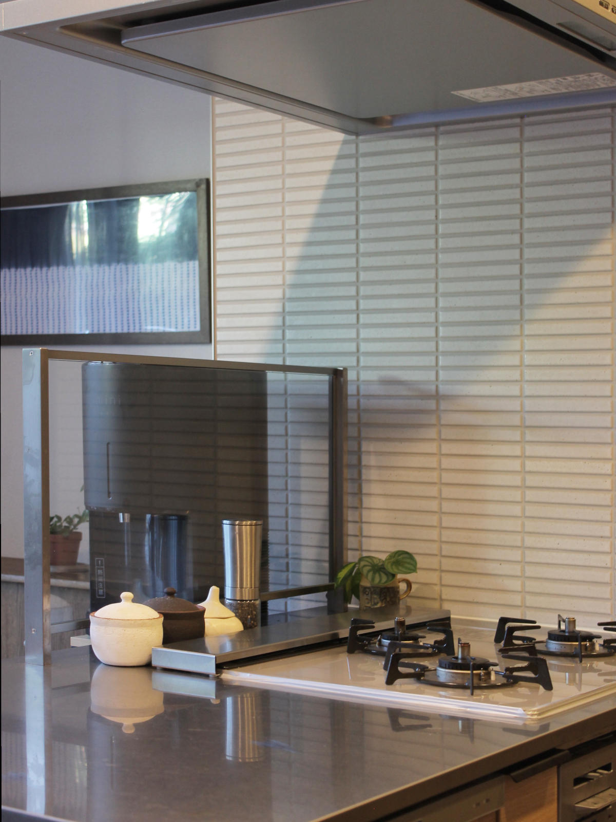 名古屋市のマンションキッチンリフォーム。白いタイル壁KB-M-71が柔らかで清潔感ある印象をプラス。ステンレス天板との相性も抜群。