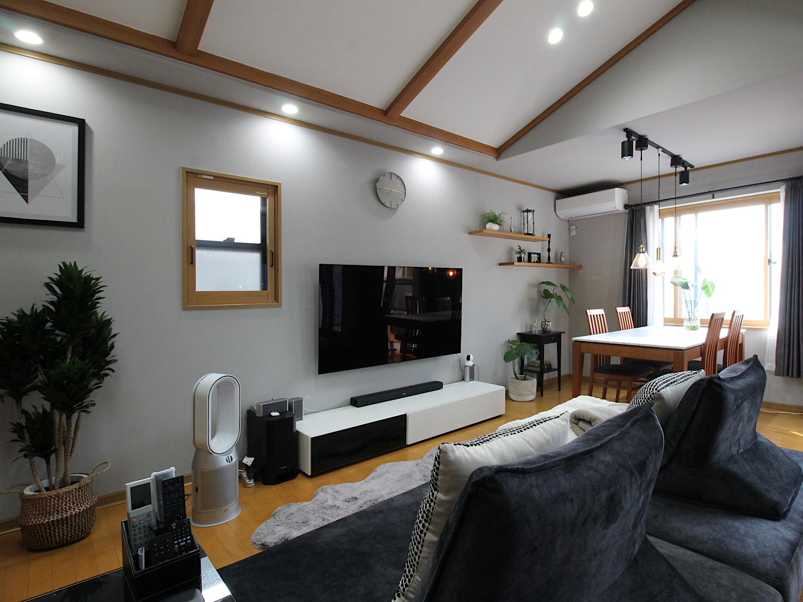 戸建てリビング内装リフォーム。サンゲツクロス【RE5305】でグレートーンに統一。木製建具と観葉植物のコーディネートが心地よい。