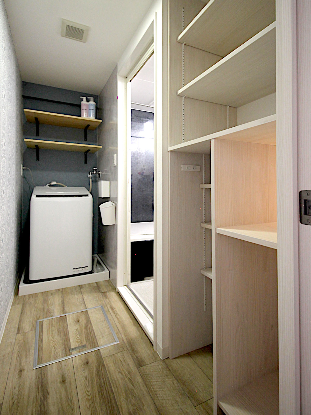 マンションリノベーション事例。洗面化粧台ドレーナとランドリールームをつなぐ小窓を設け、タオルの受け渡しができる便利な動線設計。