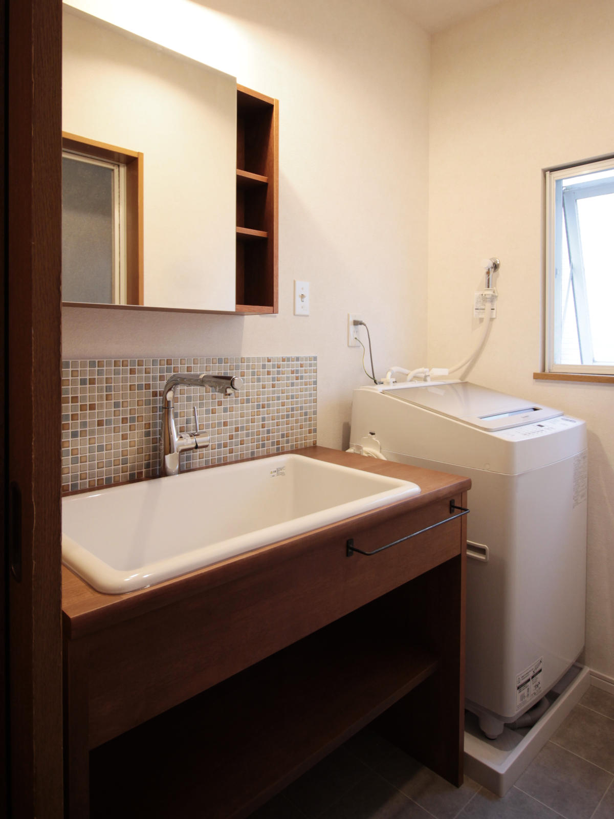 戸建てリノベーション。造作集成材カウンターとToolboxのボックスミラーで構成した洗面所。タイルの質感と木のあたたかみが調和するカントリースタイル。