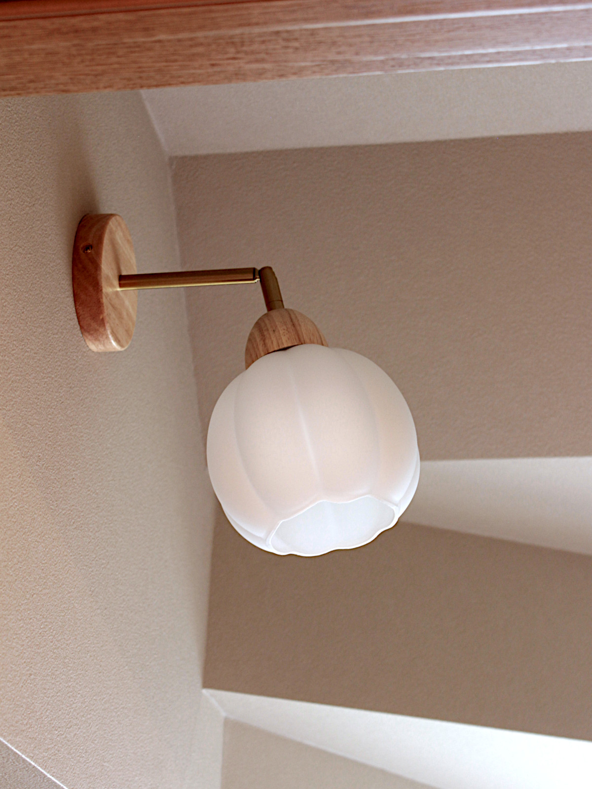 戸建てトイレのリノベーション。花形のガラスシェードが目を引くブラケットライトが、カントリーな雰囲気を演出する北名古屋市の施工事例。