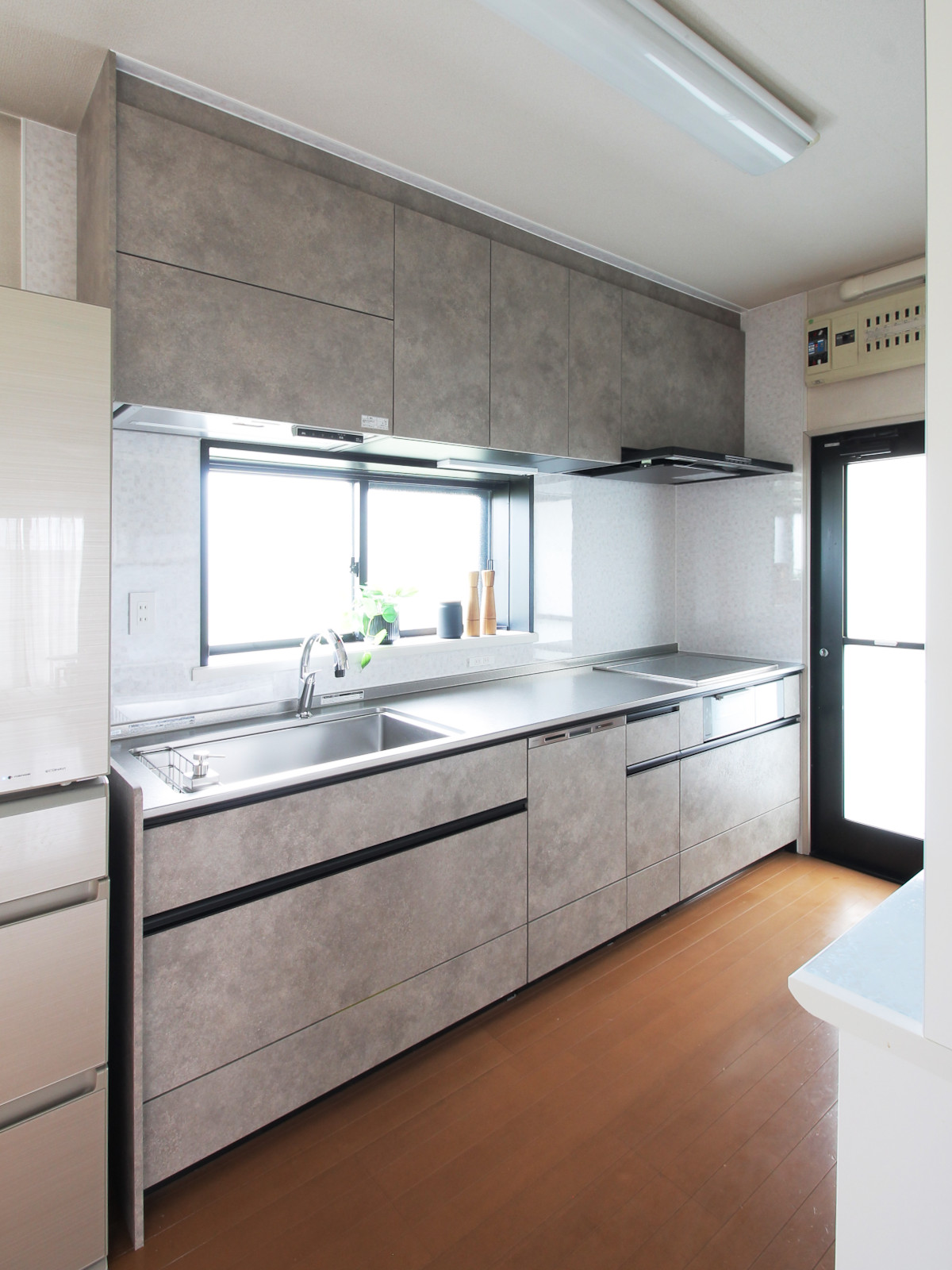 北名古屋市の戸建てのキッチンリフォーム事例。クリナップ「CENTRO(セントロ)」W2700タイプを採用。ロカグレージュ扉とPanasonicの深型食洗器を組み合わせ、直線的でスタイリッシュな空間に仕上げた全景写真。