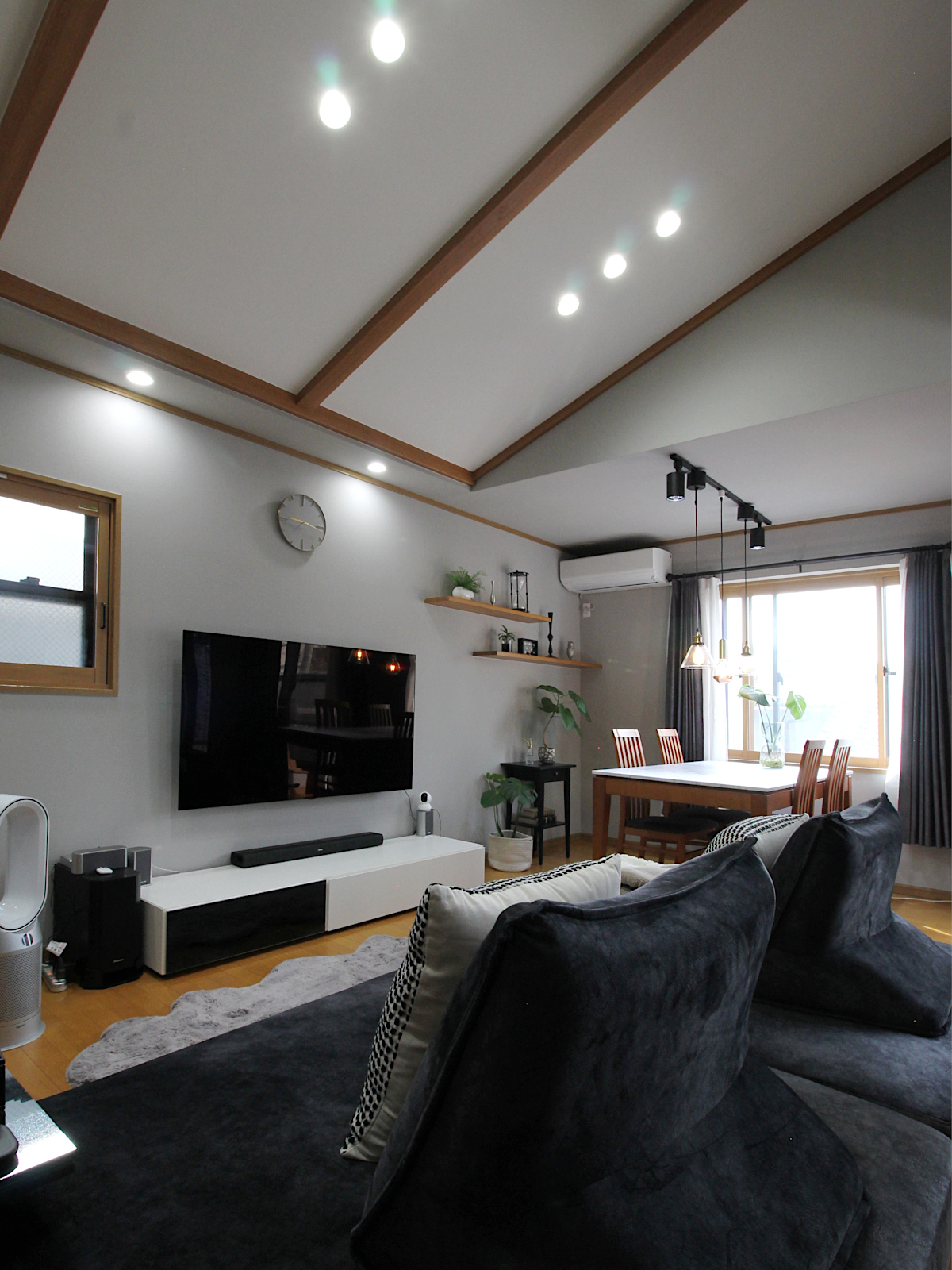 戸建てリビング内装リフォーム。サンゲツクロス【RE5305】でグレートーンに統一。木製建具と観葉植物のコーディネートが心地よい。